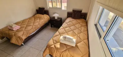 two beds in a room with a window at 3 Bedroom Penthouse Livadia Larnaca in Livadhia