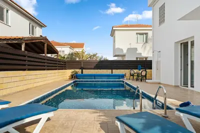 a swimming pool in a backyard with blue chairs at Villa St George - 3 Bed Villa with Private Pool in Xylophaghou
