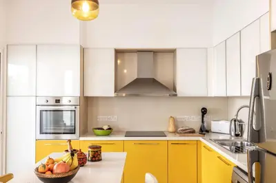 a kitchen with yellow cabinets and a bowl of fruit on a counter at Protaras Seaside Villa Narcissos 2 in Protaras