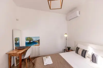 a bedroom with a white bed and a desk at Protaras Seaside Villa Narcissos 2 in Protaras