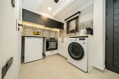 a kitchen with a washing machine and a washer at New luxury studio in the historic center in Limassol