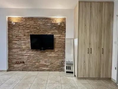 a living room with a tv on a brick wall at STAY Sunsea Studio in Limassol