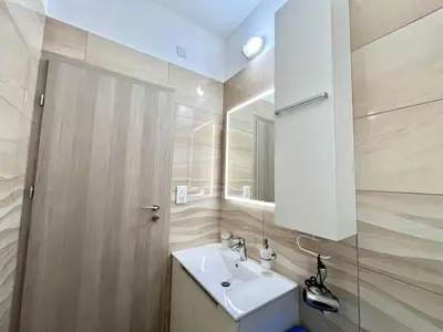 a bathroom with a white sink and a mirror at STAY Sunsea Studio in Limassol