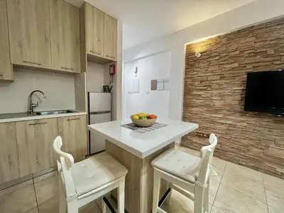 a kitchen with a table and two chairs and a sink at STAY Sunsea Studio in Limassol