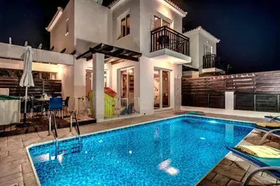 a large swimming pool in front of a house at Pernera Sunrise Villa in Paralimni