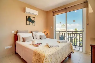 a bedroom with a bed and a balcony at Pernera Sunrise Villa in Paralimni