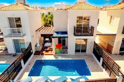 a villa with a swimming pool in front of a house at Pernera Sunrise Villa in Paralimni
