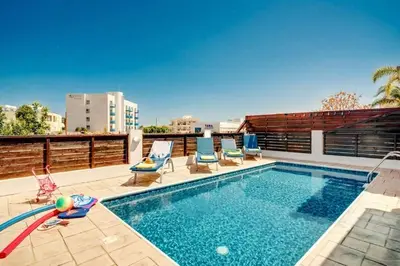 a swimming pool with lounge chairs on a roof at Pernera Sunrise Villa in Paralimni