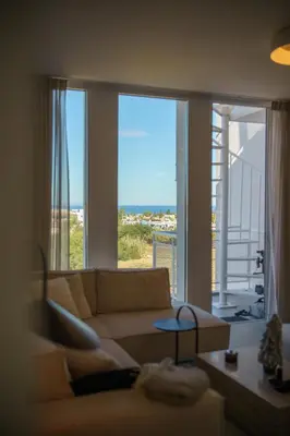 a living room with a couch and a view of the ocean at Blue Horizon Seaview Suite with Rooftop and Pool in Paralimni in Paralimni