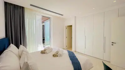 a bedroom with a white bed with slippers on it at Villa Cielo Mare in Ayia Napa