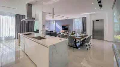 a kitchen and living room with a table and chairs at Villa Cielo Mare in Ayia Napa
