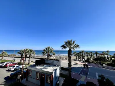 a house with palm trees and the ocean in the background at STAY Atalanta Apartment in Larnaka