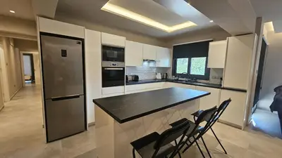 a kitchen with a counter and some chairs in it at STAY Executive Retreat in Nicosia