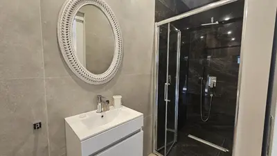 a bathroom with a sink and a shower and a mirror at STAY Executive Retreat in Nicosia
