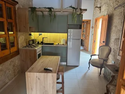 a kitchen with a refrigerator and a wooden table at Stone house in Pallouriotissa