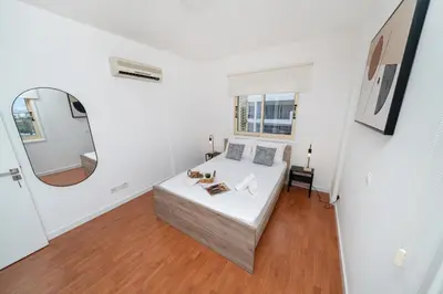 a bedroom with a bed and a mirror at 1 bedroom flat in Nicosia