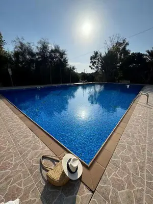 a straw hat sitting next to a blue swimming pool at Summer Breeze apt by Nissi Beach in Ayia Napa