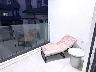 a bathroom with a chair and a toilet on a balcony at Luna Mare in Limassol