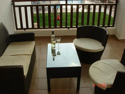 a table and chairs with wine glasses on a balcony at 2 Bed apartment with huge balcony overlooking pool in Paralimni
