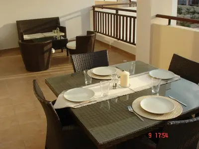 a table with plates and glasses on top of it at 2 Bed apartment with huge balcony overlooking pool in Paralimni