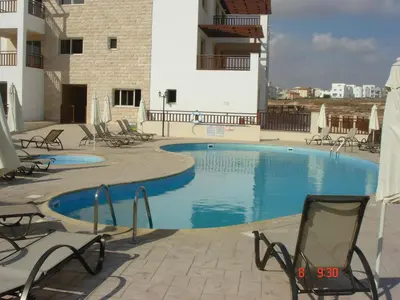 a swimming pool on the side of a building at 2 Bed apartment with huge balcony overlooking pool in Paralimni