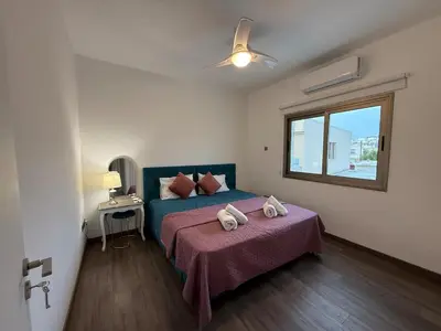a bedroom with a bed with two towels on it at Bella's Place - Stylish 2BD With large Veranda in Larnaka