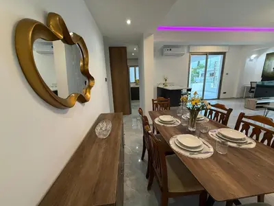 a dining room with a wooden table and a mirror at Bella's Place - Stylish 2BD With large Veranda in Larnaka