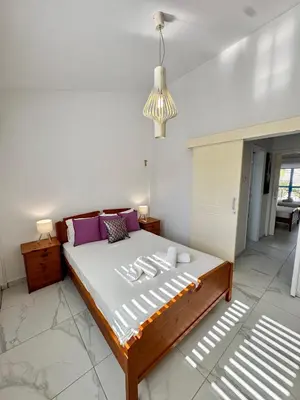 a bedroom with a large bed with purple pillows at Modern 2BR Villa with Heated Hot Tub and Steps to Beach in Paralimni