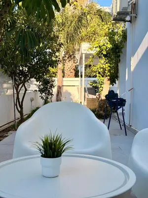 a white table with a potted plant on a patio at Modern 2BR Villa with Heated Hot Tub and Steps to Beach in Paralimni