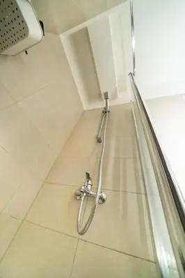 a shower in a room with a tile floor at 1 bedroom flat near center in Nicosia