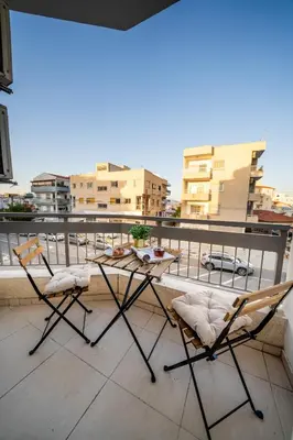 two chairs on a balcony with a view of a city at 1 bedroom flat near center in Nicosia