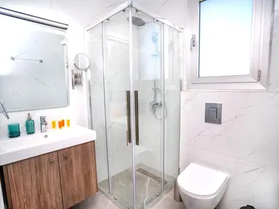 a bathroom with a shower and a toilet and a sink at Celeste Suites in Limassol