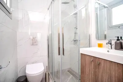 a bathroom with a shower and a toilet and a sink at Celeste Suites in Limassol
