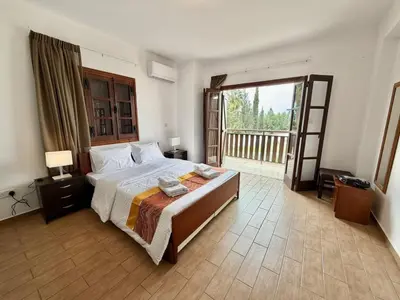 a bedroom with a large bed and a balcony at Villa Encanto - Private Heated Swimming Pool for winter months 5Bedroom in Voroklini