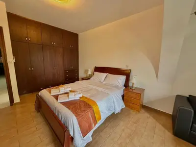 a bedroom with a large bed with wooden cabinets at Villa Encanto - Private Heated Swimming Pool for winter months 5Bedroom in Voroklini