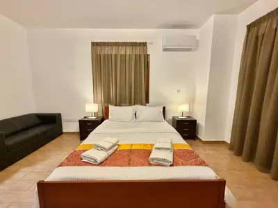 a bedroom with a large bed and a couch at Villa Encanto - Private Heated Swimming Pool for winter months 5Bedroom in Voroklini