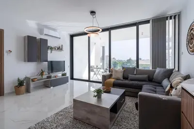 a living room with a couch and a table at Taupe's 2-BR Apartment & Balcony in Larnaca in Livadhia