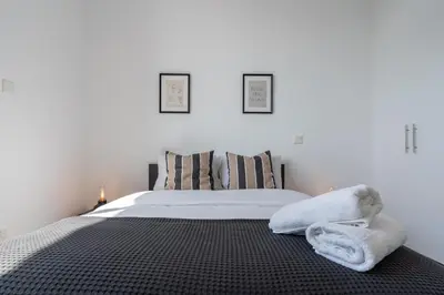a bedroom with a bed with two towels on it at Taupe's 2-BR Apartment & Balcony in Larnaca in Livadhia
