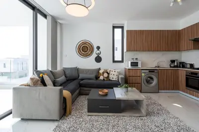 a living room with a couch and a table at Taupe's 2-BR Apartment & Balcony in Larnaca in Livadhia