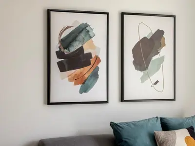 two framed art prints on a white wall with a couch at Mythical Sands AL14 in Paralimni