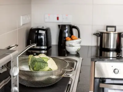 a kitchen with a bowl of lettuce in a strainer at Mythical Sands AL14 in Paralimni