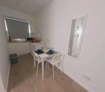a small white table and chairs in a room at Athalassas corner in Strovolos