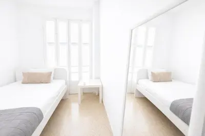 a white room with two beds and a mirror at Cozy Corner 2 Bdr Nicosia Center Platform 357 Ltd in Nicosia