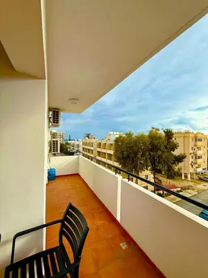 a balcony with a chair and a view of a city at Carisa rooms for holiday in Larnaka