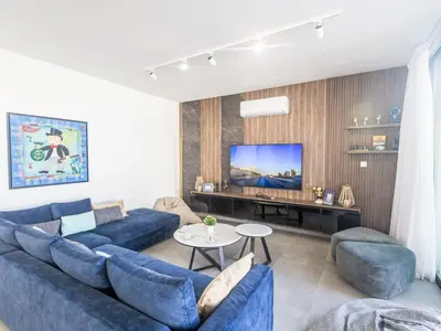 a living room with blue couches and a flat screen tv at Holiday Home Protaras Aqua Pearl Villa AQ18 mit Poolheizung by Interhome in Protaras