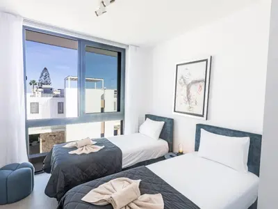 two beds in a room with a window at Holiday Home Protaras Aqua Pearl Villa AQ18 mit Poolheizung by Interhome in Protaras
