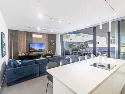 a living room with a blue couch and a tv at Holiday Home Protaras Aqua Pearl Villa AQ18 mit Poolheizung by Interhome in Protaras