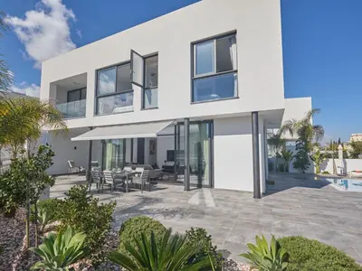 a white house with a patio and a pool at Holiday Home Protaras Almaria Villa ALM08 by Interhome in Protaras