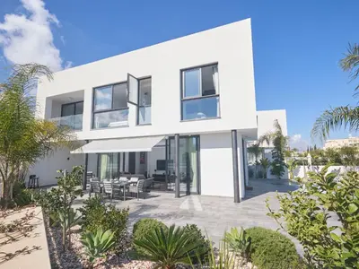 an exterior view of a white house with plants at Holiday Home Protaras Almaria Villa ALM08 by Interhome in Protaras