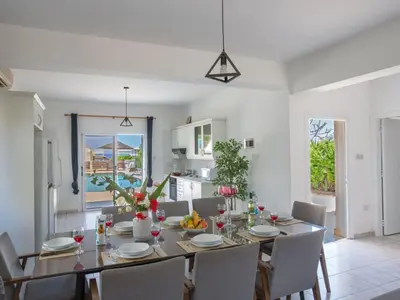 a kitchen and dining room with a table and chairs at Holiday Home Protaras Villa mit Pool am Strand der Fig Tree Bay by Interhome in Protaras
